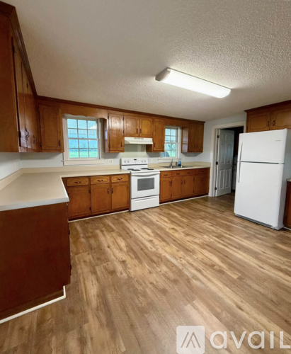 A kitchen with wooden cabinets and a white refrigerator.