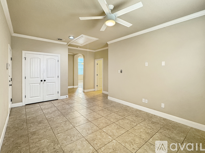 A spacious room with a fan and tile flooring.