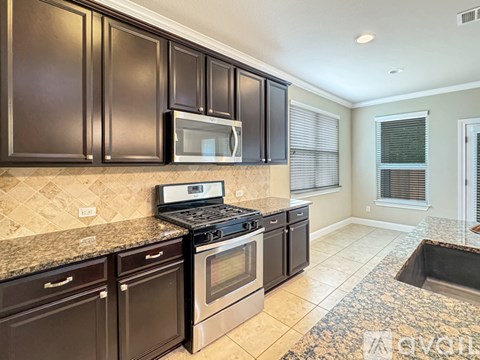 A kitchen with brown cabinets and a black stove top oven.
