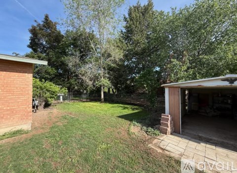 A backyard with a brick building and a garage.