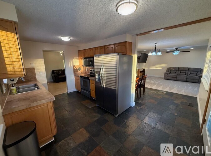 A kitchen with a checkered floor and a refrigerator in the middle.