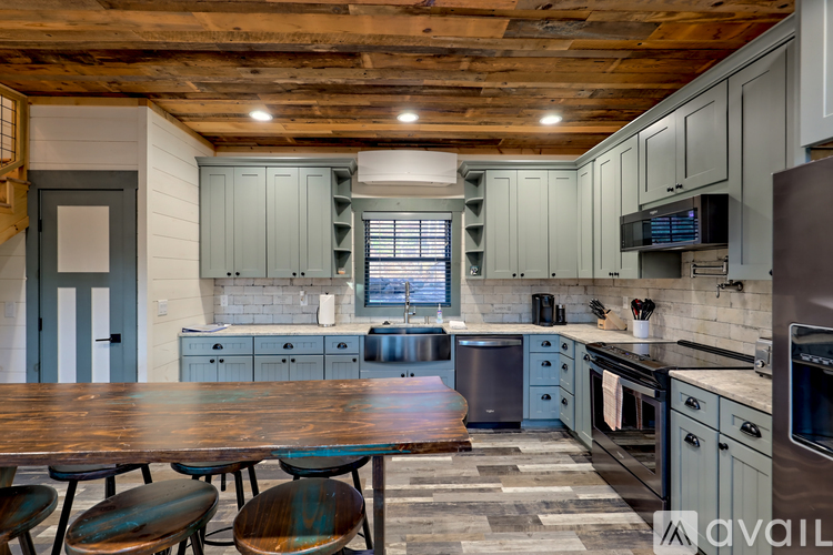 A kitchen with a wooden ceiling and a table with chairs.