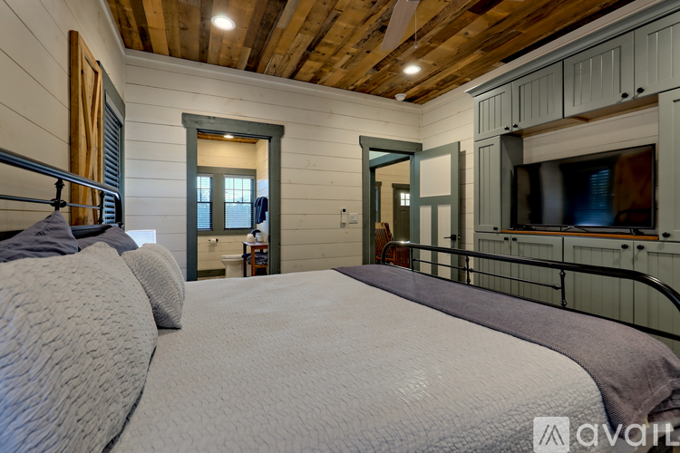 A bedroom with a large bed and a wooden ceiling.
