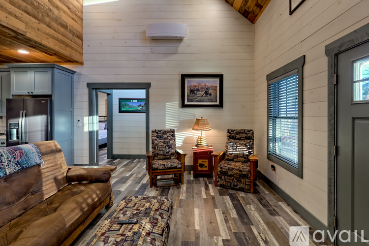 A living room with a brown couch and a wooden floor.