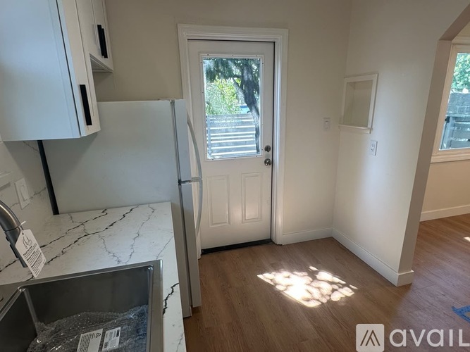 A kitchen with a marble countertop and a refrigerator.