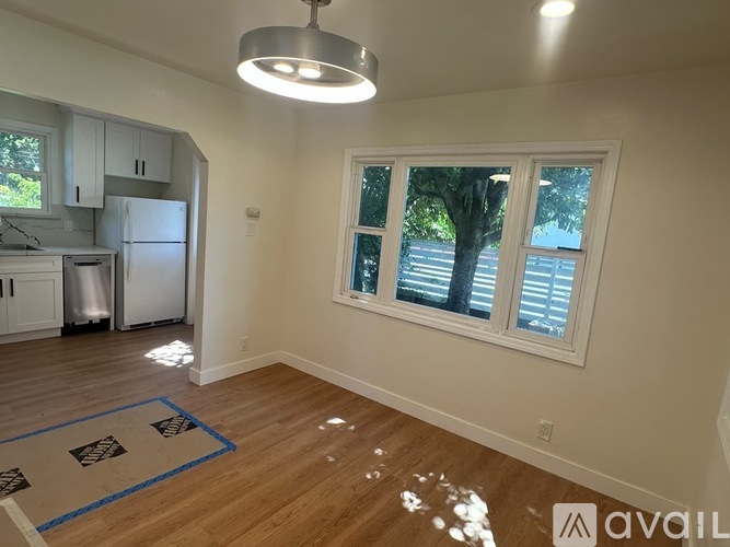 A kitchen with white cabinets and a refrigerator is shown.