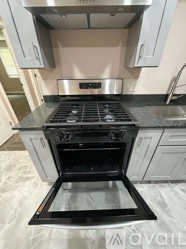 A modern kitchen with a stove top oven and a digital control panel.