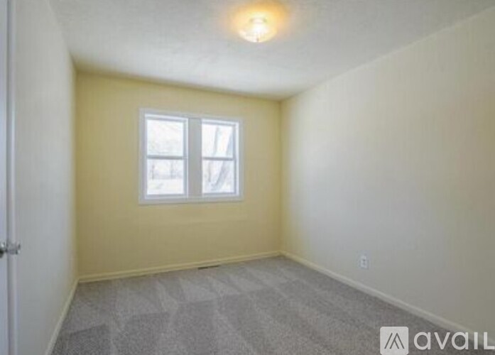 A room with a carpeted floor and a window.
