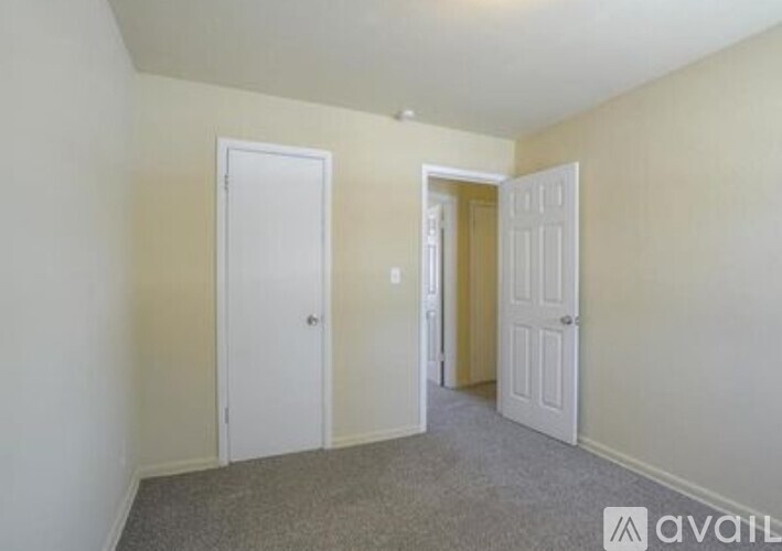 A room with two doors and a carpeted floor.