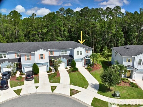 A yellow arrow points to a house in a residential neighborhood.