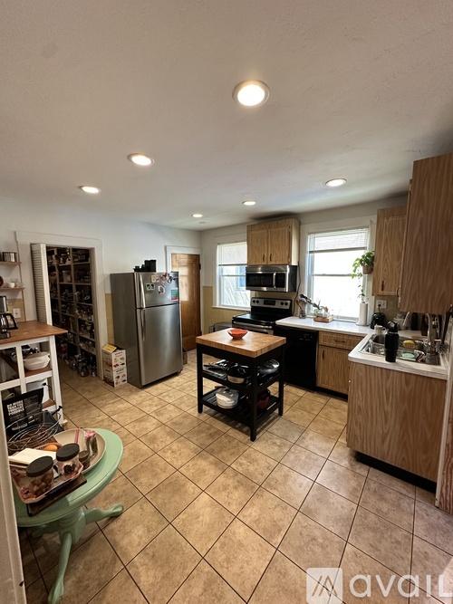 A kitchen with a refrigerator, oven, and sink.