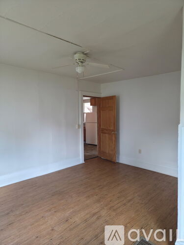A room with wooden floors and a ceiling fan.