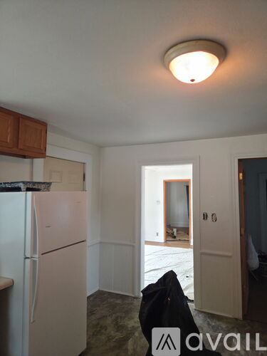 A kitchen with a white fridge and a white ceiling light.