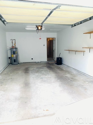 A kitchen area with a sink, cabinets, and a refrigerator.