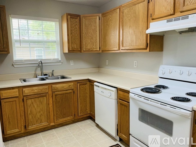 A kitchen with wooden cabinets and white appliances.