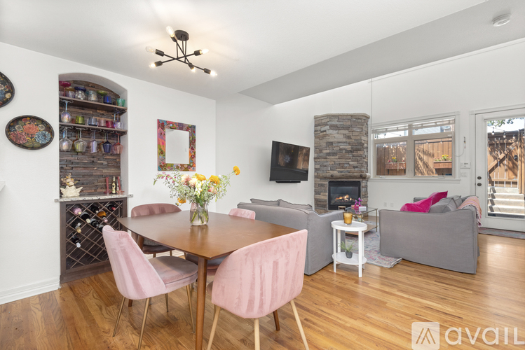 A living room with a wooden table and pink chairs.
