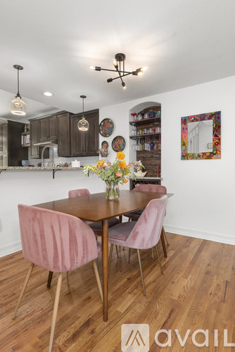 A dining room with a wooden table and chairs.