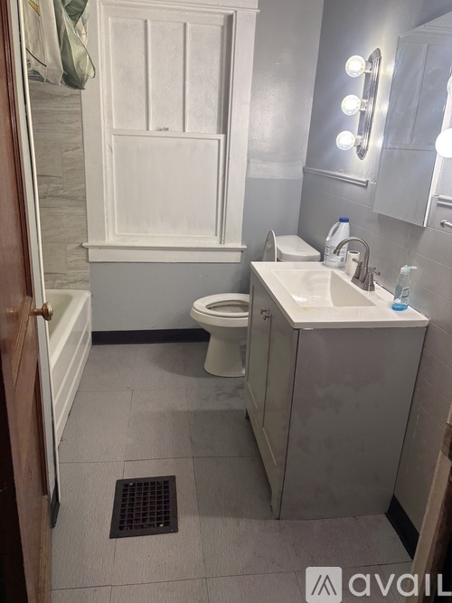 A bathroom with a toilet, sink, and mirror.