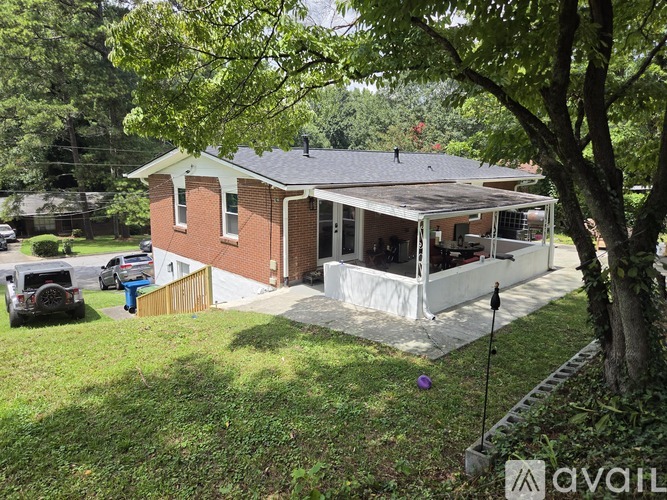 A house with a red brick exterior and a white covered patio area.