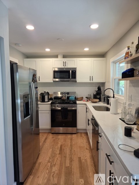 A kitchen with stainless steel appliances and wooden floors.