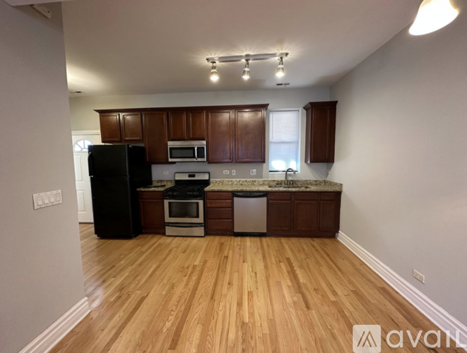 A kitchen with wooden floors and white walls.