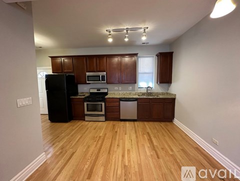 A kitchen with wooden floors and white walls.