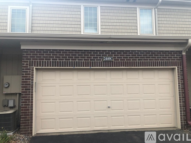 A garage door with the number 24401 on the brick wall above it.