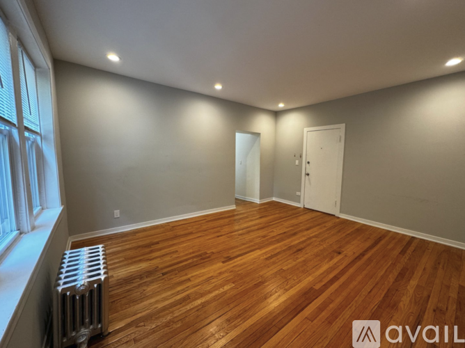 A room with wooden flooring and a radiator on the left side.