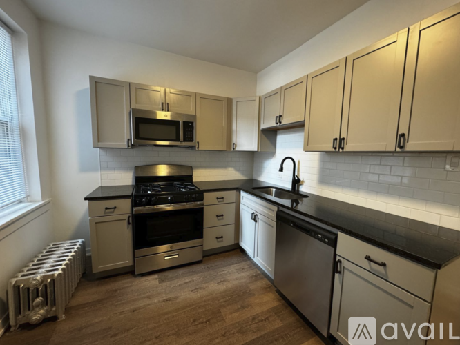 A kitchen with wooden floors and a stove top oven.