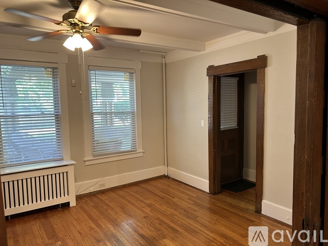 A room with a ceiling fan and wooden floors.