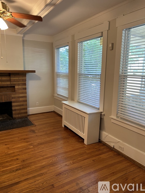 A room with a fireplace and a window with blinds.
