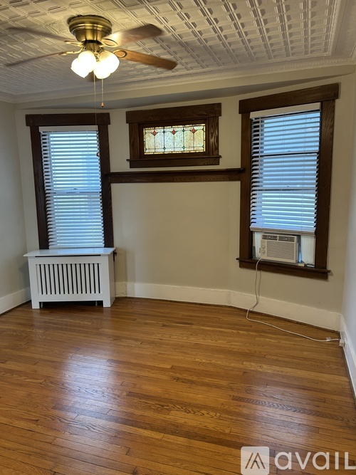 A room with wooden floors and a ceiling fan.