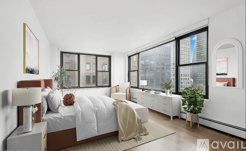 A bedroom with a large bed and a view of the city through the window.