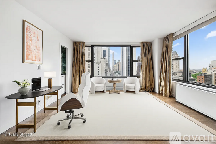 A living room with a view of the cityscape through the windows.