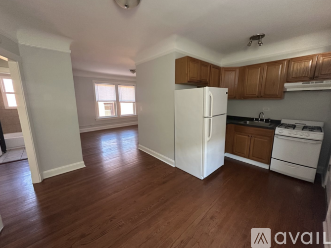 A kitchen with white appliances and wooden cabinets.