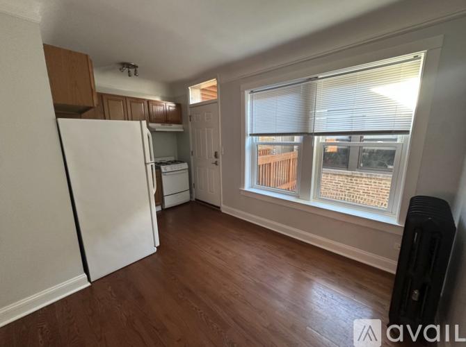 A kitchen with a white refrigerator and wooden floors.