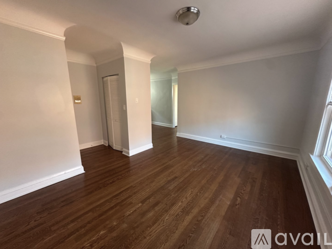 A room with wooden flooring and white walls.