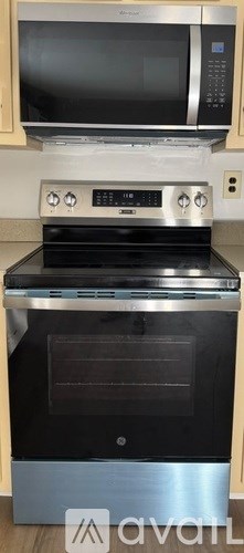 A modern kitchen with a stainless steel oven and microwave above it.