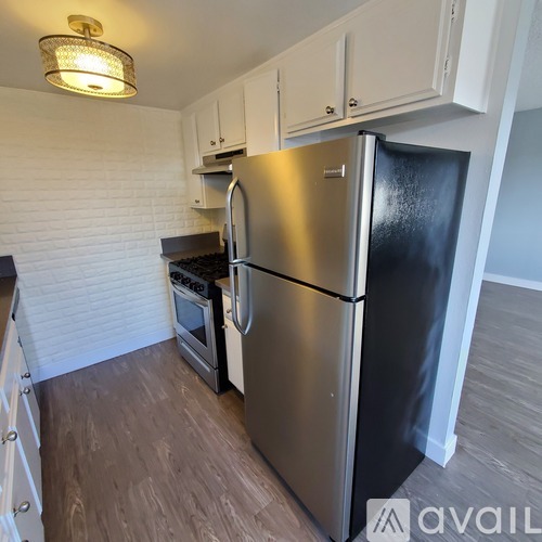 A kitchen with a stainless steel refrigerator and a stove top oven.