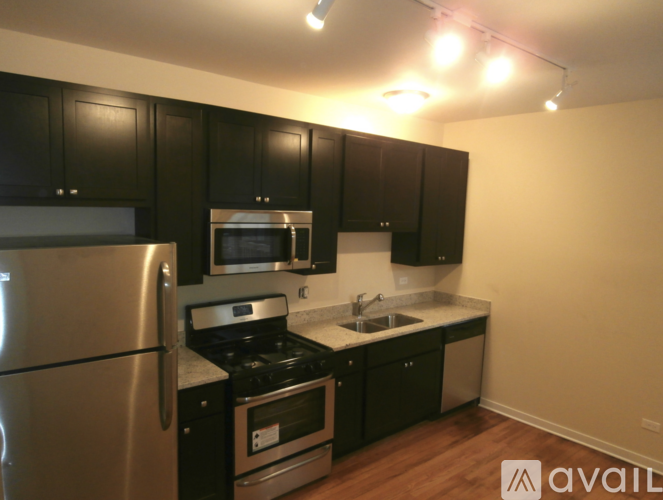 A kitchen with black cabinets and stainless steel appliances.