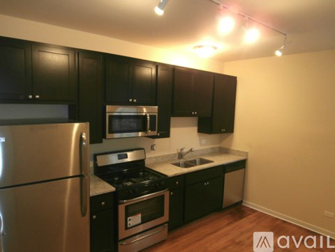 A kitchen with black cabinets and stainless steel appliances.