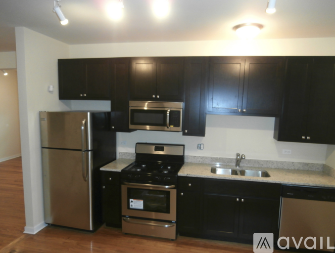 A kitchen with black cabinets and stainless steel appliances.