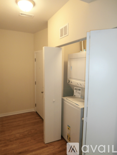 A small kitchen with a white fridge and a white door.