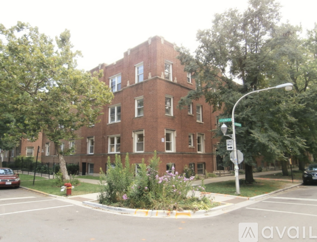 A street view of a red brick building with a traffic light in front.