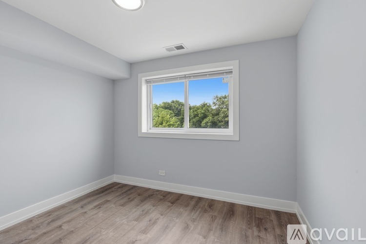 A room with a window showing trees outside.