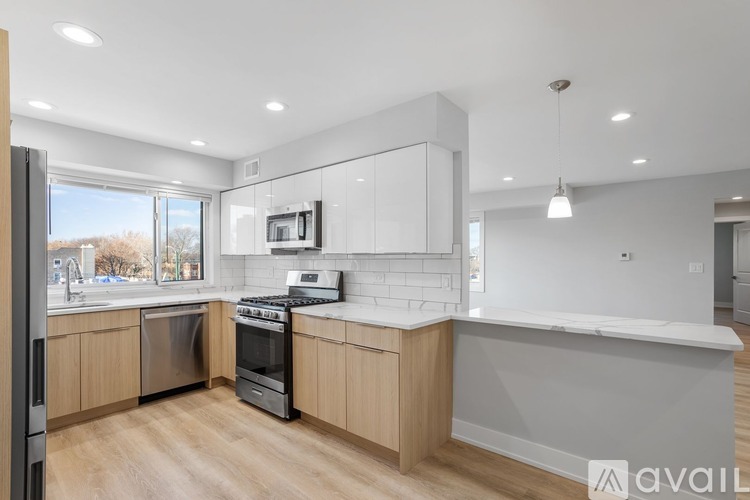 A modern kitchen with wooden cabinets and stainless steel appliances.