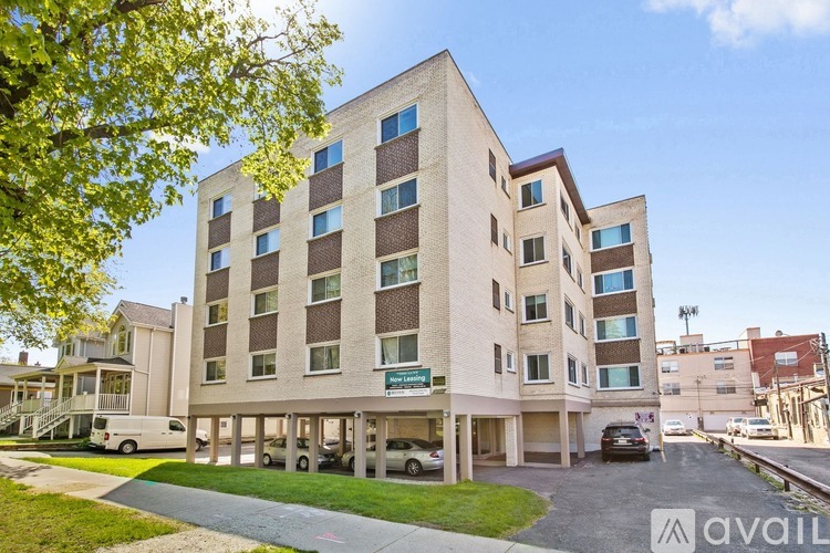A modern apartment building with a parking lot in front.