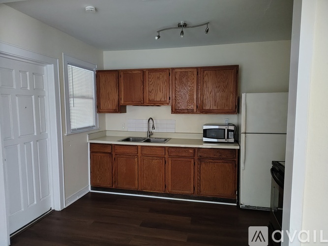 A kitchen with wooden cabinets and a white fridge.