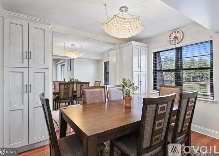 A dining room with a wooden table and chairs.