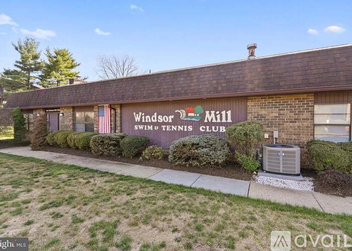 A brick building with a sign that says Windsor Mill Swim and Tennis Club.